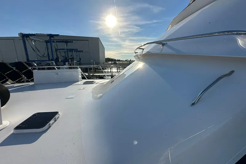 So Blessed Yacht Photos Pics 1998 Viking 54 Motor Yacht deck under bright sun, near a marina building.