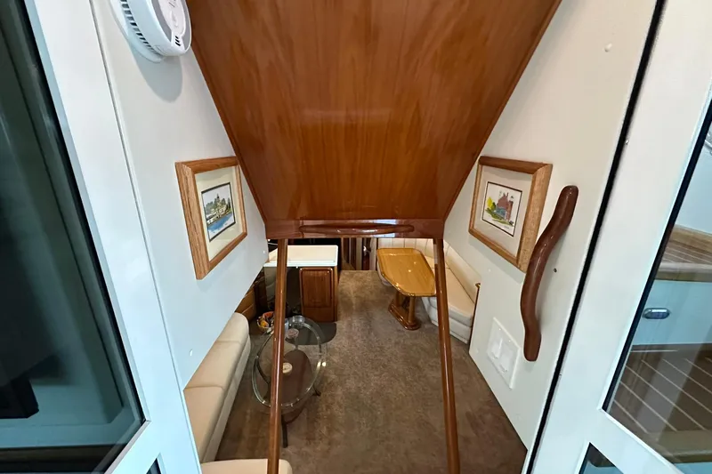 So Blessed Yacht Photos Pics Interior view of 1998 Viking 54 Motor Yacht with wooden accents and framed artwork.
