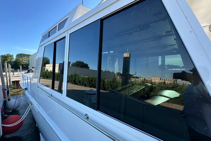 So Blessed Yacht Photos Pics 1998 Viking 54 Motor Yacht docked, reflecting clear blue sky and surrounding greenery.