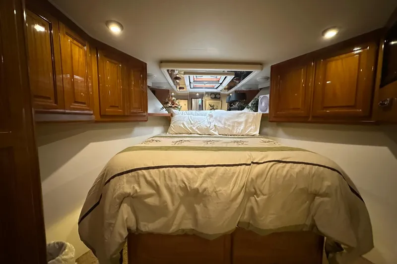 So Blessed Yacht Photos Pics Luxurious bedroom interior of 1998 Viking 54 Motor Yacht with wood cabinetry and cozy bedding.