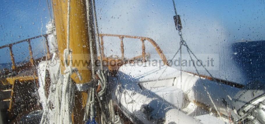 1925 Codecasa schooner deck with ropes and lifeboat, splashed by ocean waves.