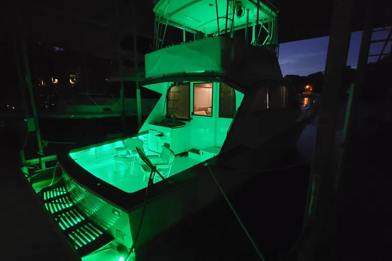  Yacht Photos Pics 1984 Post 43 Sport Fisherman yacht illuminated with green lights at night.