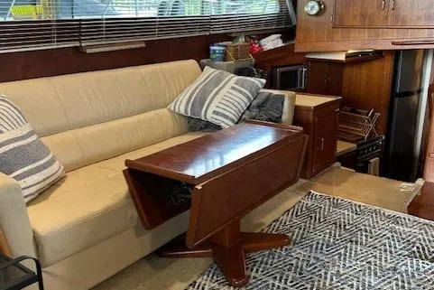  Yacht Photos Pics Interior of 1984 Post 43 Sport Fisherman with sofa, table, and kitchen area.