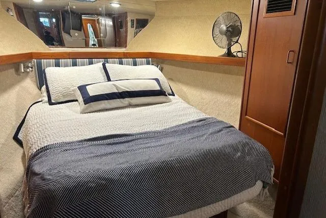  Yacht Photos Pics Cozy bedroom in 1984 Post 43 Sport Fisherman yacht with striped bedding and fan.