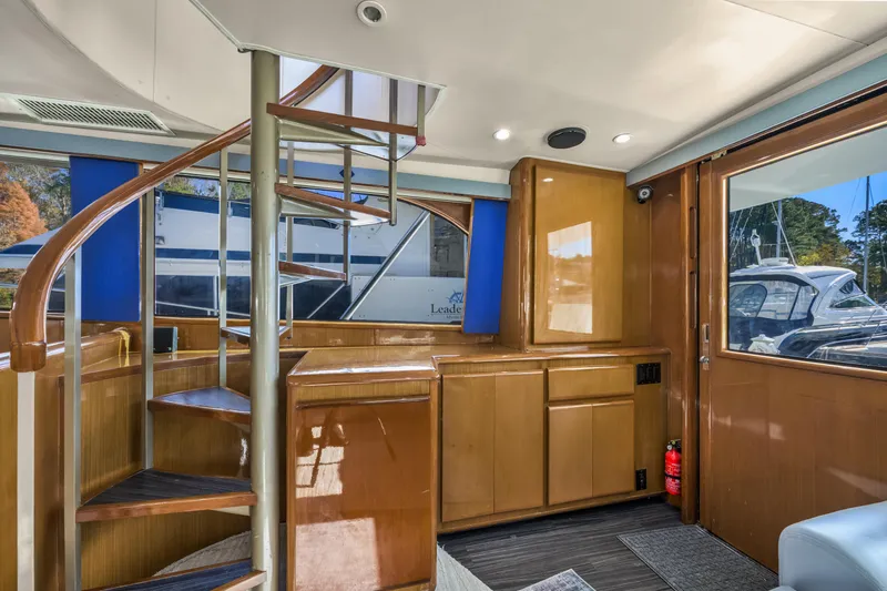 Marysea Yacht Photos Pics Interior of 1999 Viking 58 Convertible yacht with spiral staircase and wooden cabinetry.