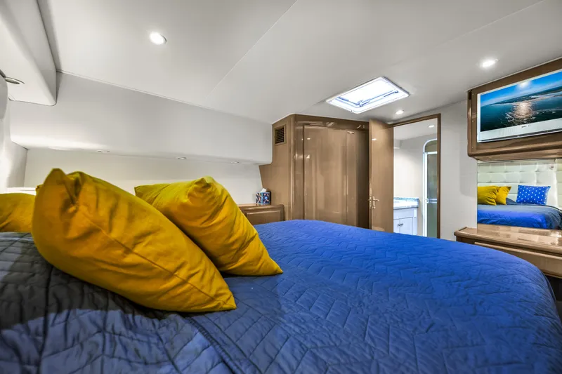 Marysea Yacht Photos Pics Luxurious bedroom interior of 1999 Viking 58 Convertible yacht with blue bedding and yellow pillows.
