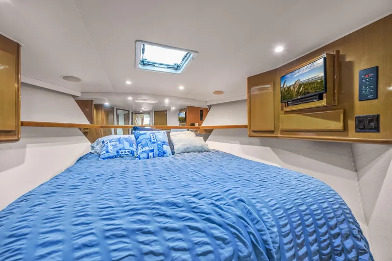 Marysea Yacht Photos Pics Luxurious cabin interior of 1999 Viking 58 Convertible yacht with blue bedding and TV.