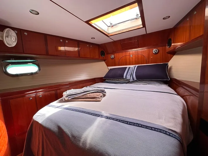 Beyond Capricorn 1 Yacht Photos Pics Luxurious cabin interior of 2001 Nordhavn 57 yacht with cozy bed and wooden finish.
