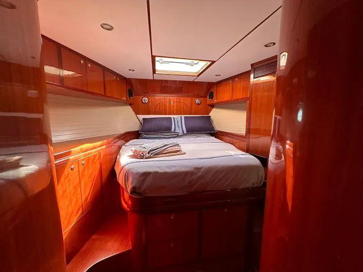 Beyond Capricorn 1 Yacht Photos Pics Luxurious cabin interior of a 2001 Nordhavn 57 yacht with wood paneling and cozy bedding.
