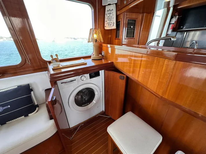 Beyond Capricorn 1 Yacht Photos Pics 2001 Nordhavn 57 yacht interior with washing machine, wooden cabinetry, and ocean view.