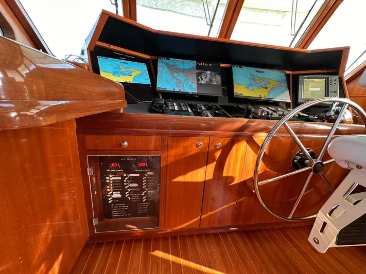Beyond Capricorn 1 Yacht Photos Pics Pilothouse of 2001 Nordhavn 57 yacht with navigation screens and wooden interior.
