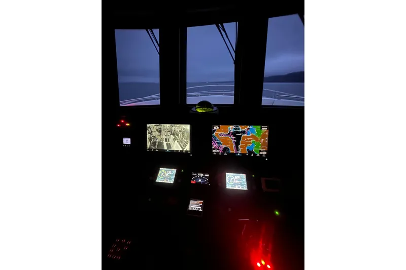 Oasis Yacht Photos Pics Pilothouse of 2024 Northwest 55 yacht with navigation screens and night view.