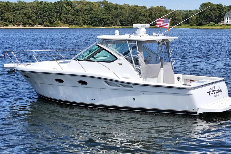 T-time Yacht Photos Pics 2006 Tiara 3200 Open yacht on calm water, American flag, scenic background.