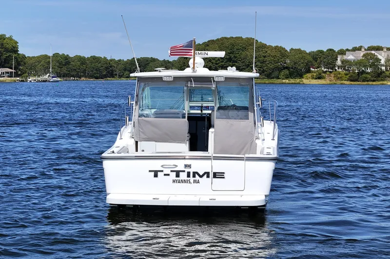 T-time Yacht Photos Pics 2006 Tiara 3200 Open boat on water, rear view, with American flag.