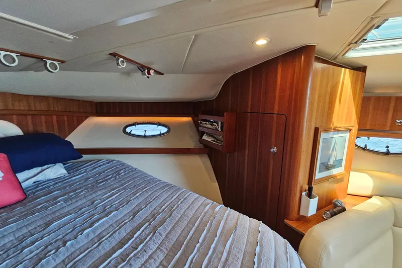 T-time Yacht Photos Pics Luxurious cabin interior of a 2006 Tiara 3200 Open yacht with wood paneling and cozy bedding.