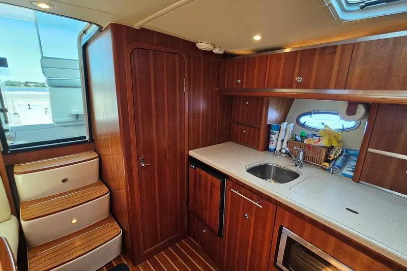 T-time Yacht Photos Pics 2006 Tiara 3200 Open yacht interior with wooden cabinetry, kitchenette, and stairs.