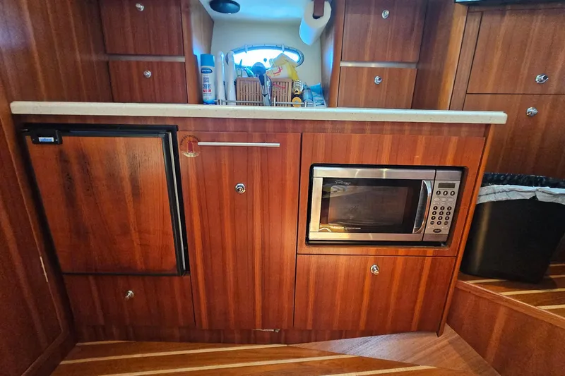 T-time Yacht Photos Pics 2006 Tiara 3200 Open yacht kitchen with wood cabinetry, microwave, and compact fridge.