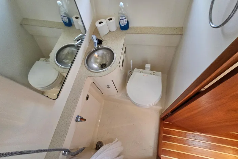 T-time Yacht Photos Pics Compact bathroom in 2006 Tiara 3200 Open yacht with sink, toilet, and mirror.