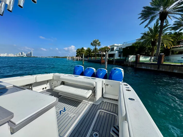  Yacht Photos Pics 2019 HCB 42 Siesta boat with four engines, docked near waterfront homes and palm trees.