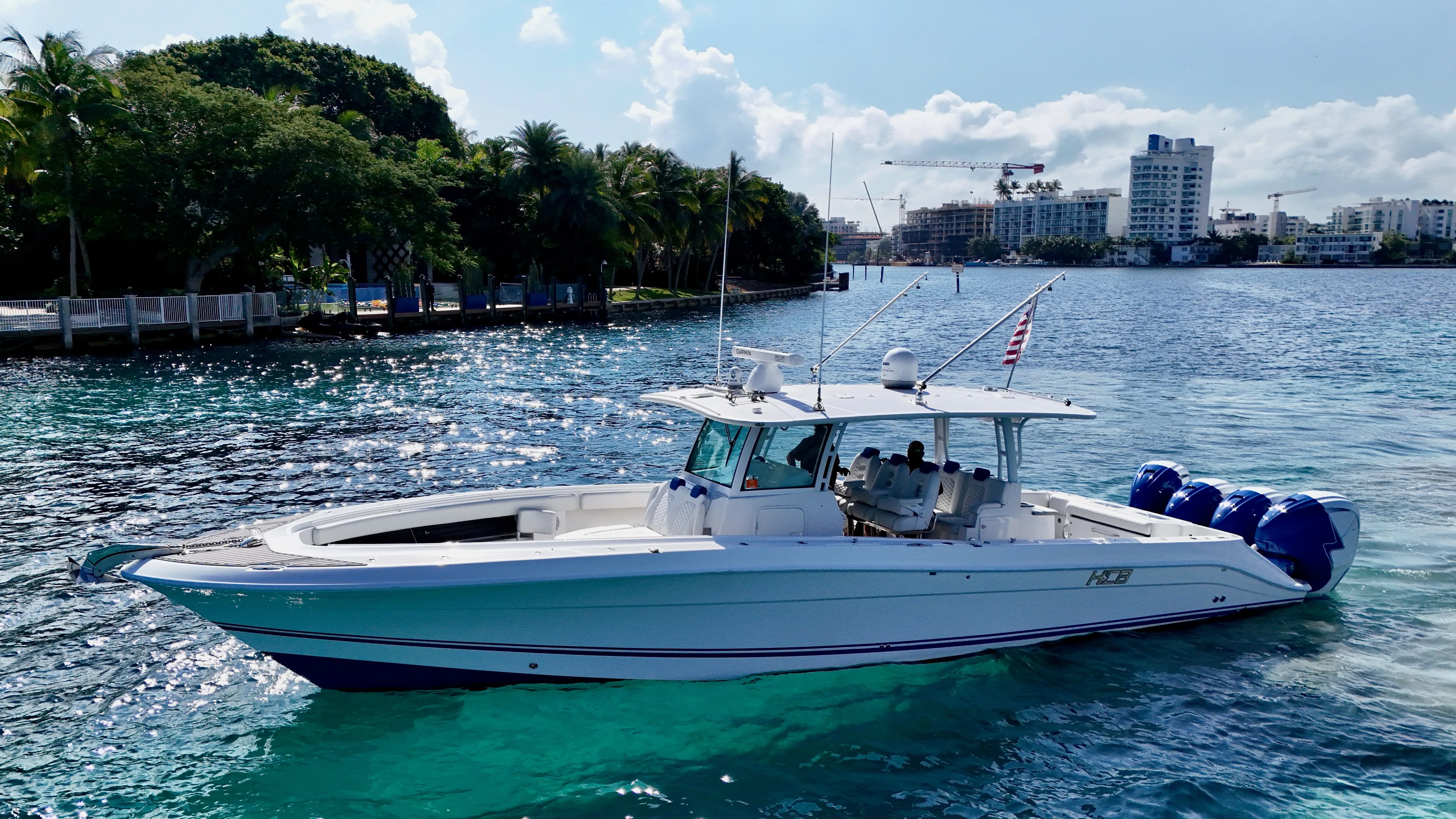  Yacht Photos Pics 2019 HCB 42 Siesta boat cruising on clear blue water near a tropical shoreline.