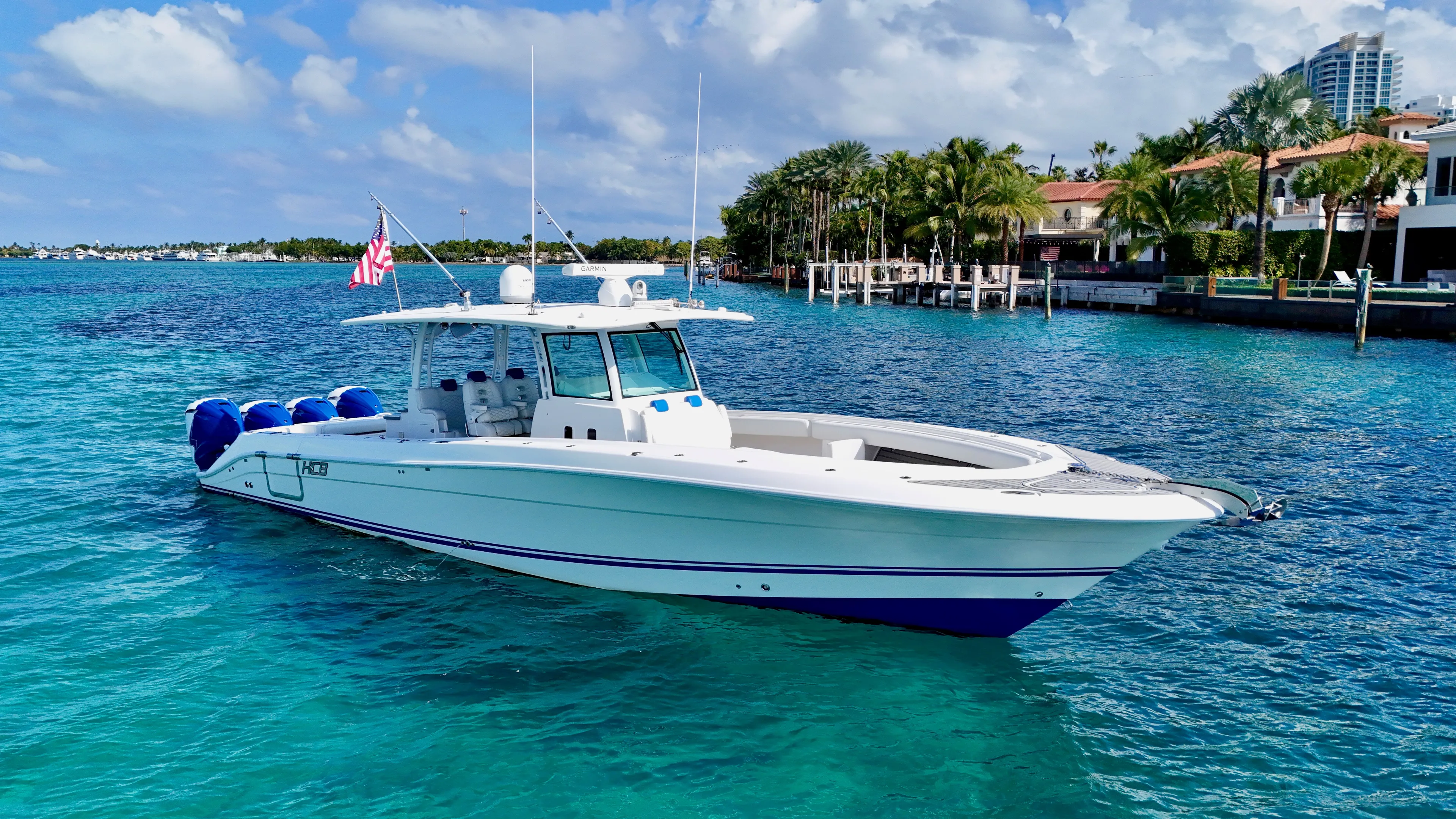  Yacht Photos Pics 2019 HCB 42 Siesta boat on clear blue water, near luxury waterfront homes.