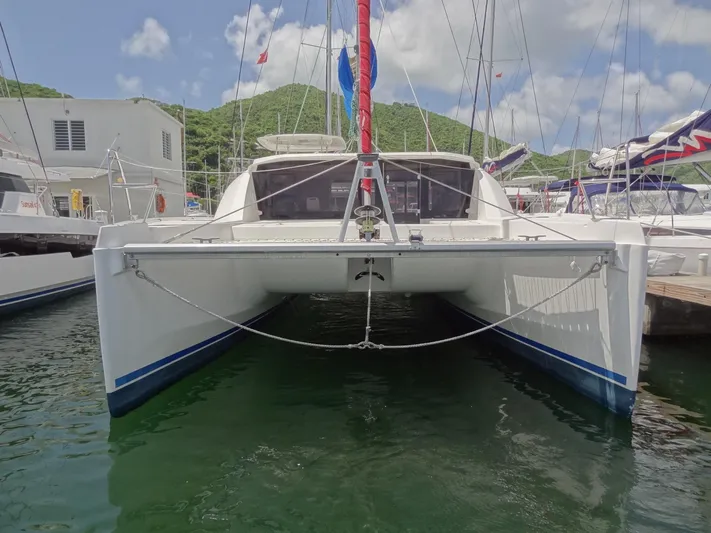 Blue Tiger Yacht Photos Pics 2021 Leopard 40 catamaran docked in marina, surrounded by lush green hills and blue sky.