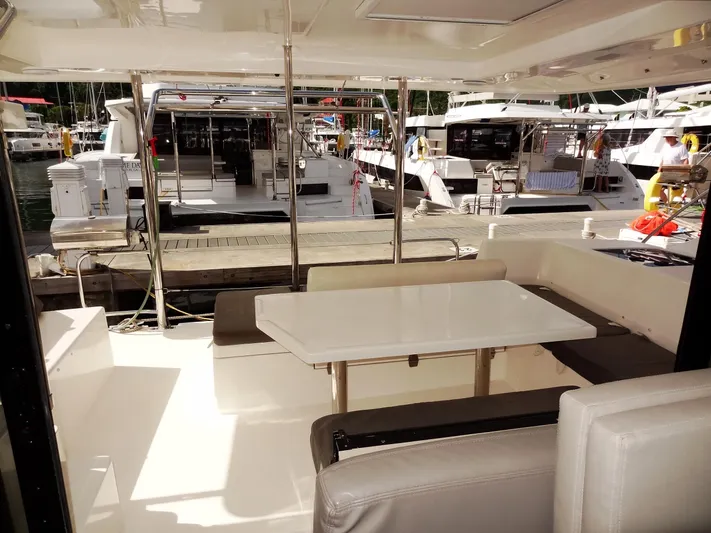 Blue Tiger Yacht Photos Pics Leopard 40 catamaran's outdoor seating area with table, docked at marina, 2021 model.