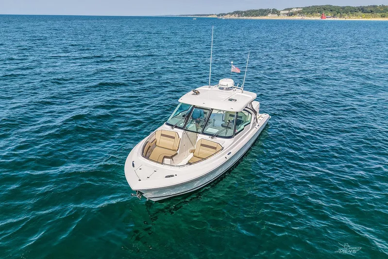 Pathfinder Yacht Photos Pics 2021 Pursuit DC 326 Dual Console boat on open water, clear sky, distant shoreline.