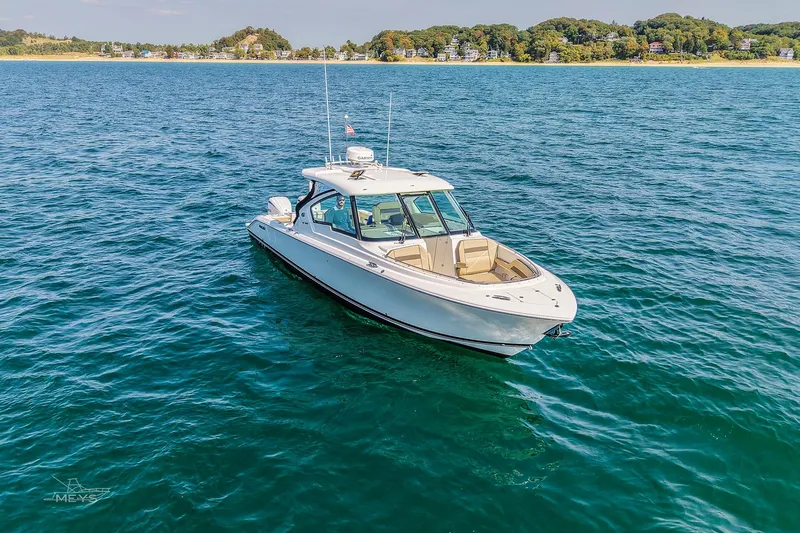 Pathfinder Yacht Photos Pics 2021 Pursuit DC 326 Dual Console boat on open water near a scenic shoreline.