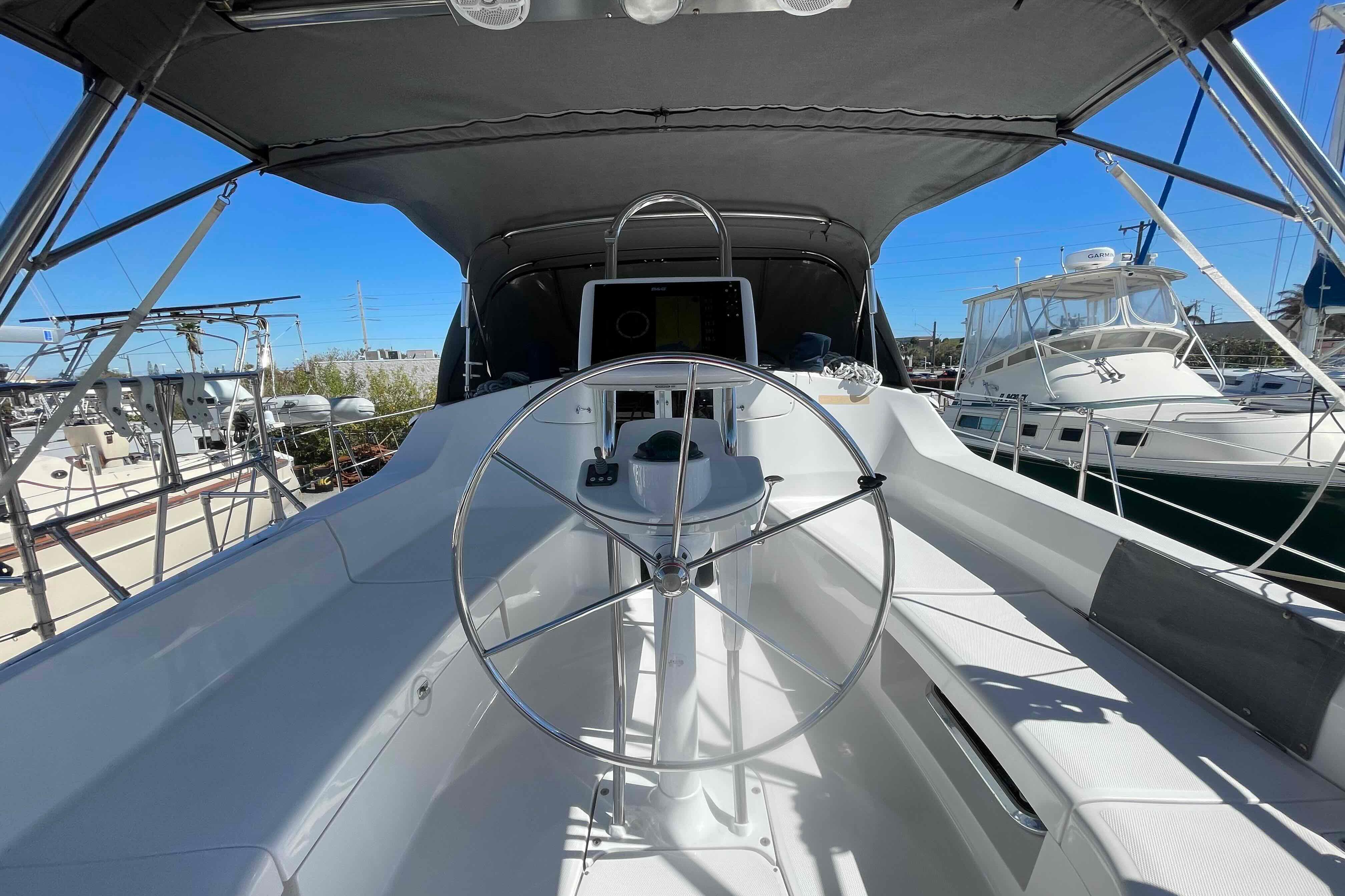 2003 Hunter 426 Deck Salon yacht cockpit with steering wheel, docked in marina.