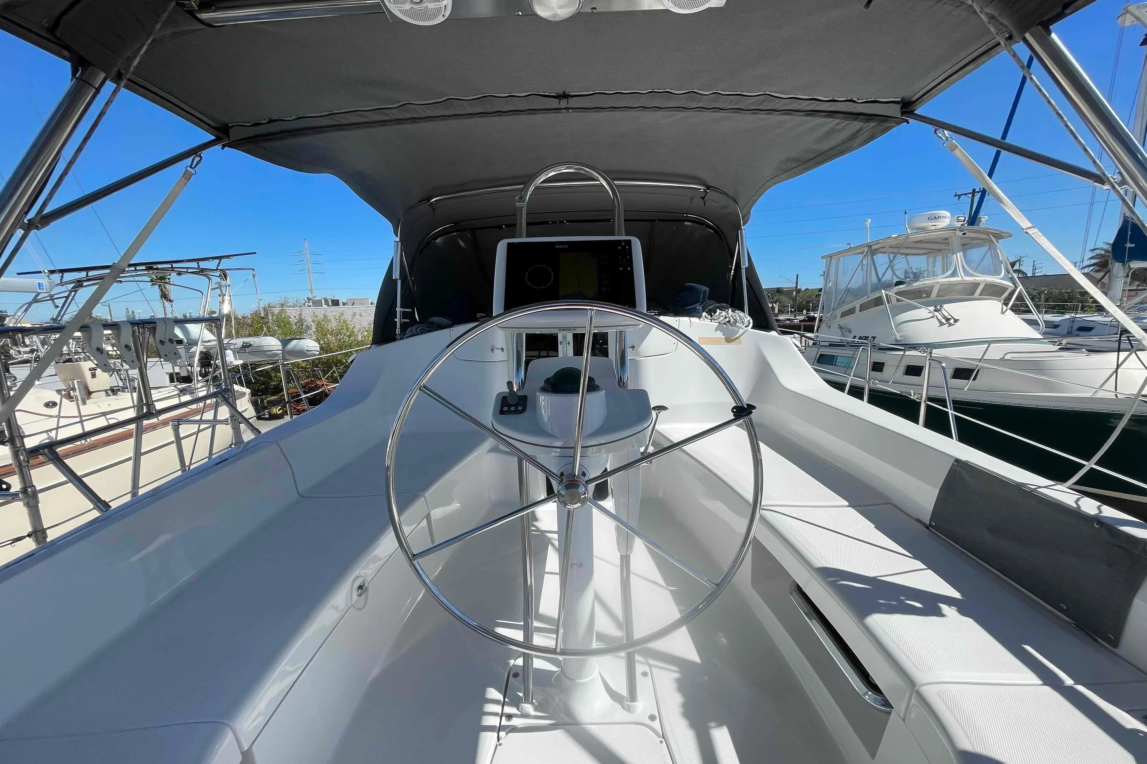 2003 Hunter 426 Deck Salon yacht cockpit with steering wheel, docked in marina.