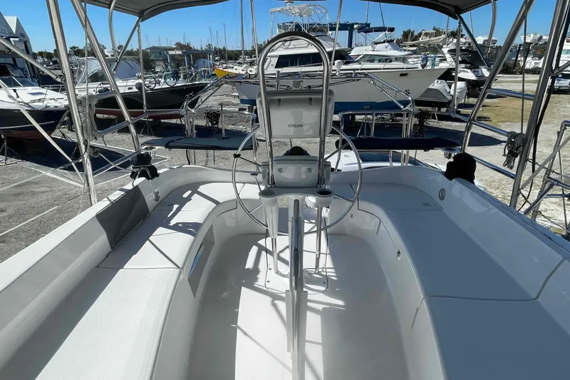 La Veda Yacht Photos Pics 2003 Hunter 426 Deck Salon sailboat cockpit with steering wheel, docked among other boats.