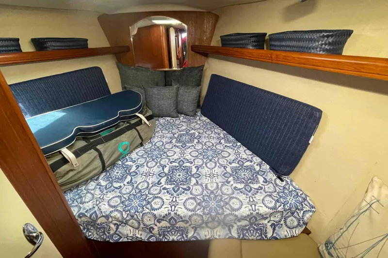 La Veda Yacht Photos Pics Cozy cabin interior of 2003 Hunter 426 Deck Salon with patterned bedding and storage baskets.