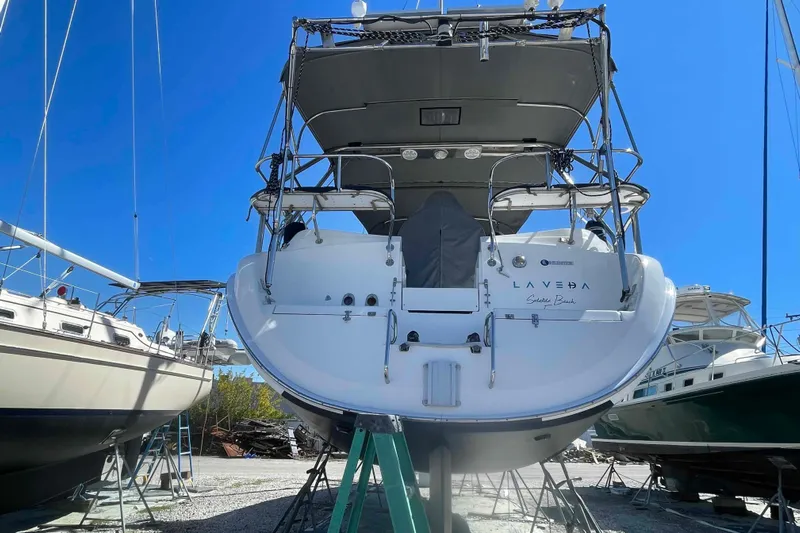 La Veda Yacht Photos Pics Hunter 426 Deck Salon 2003 sailboat on stands, viewed from the stern, under clear blue sky.