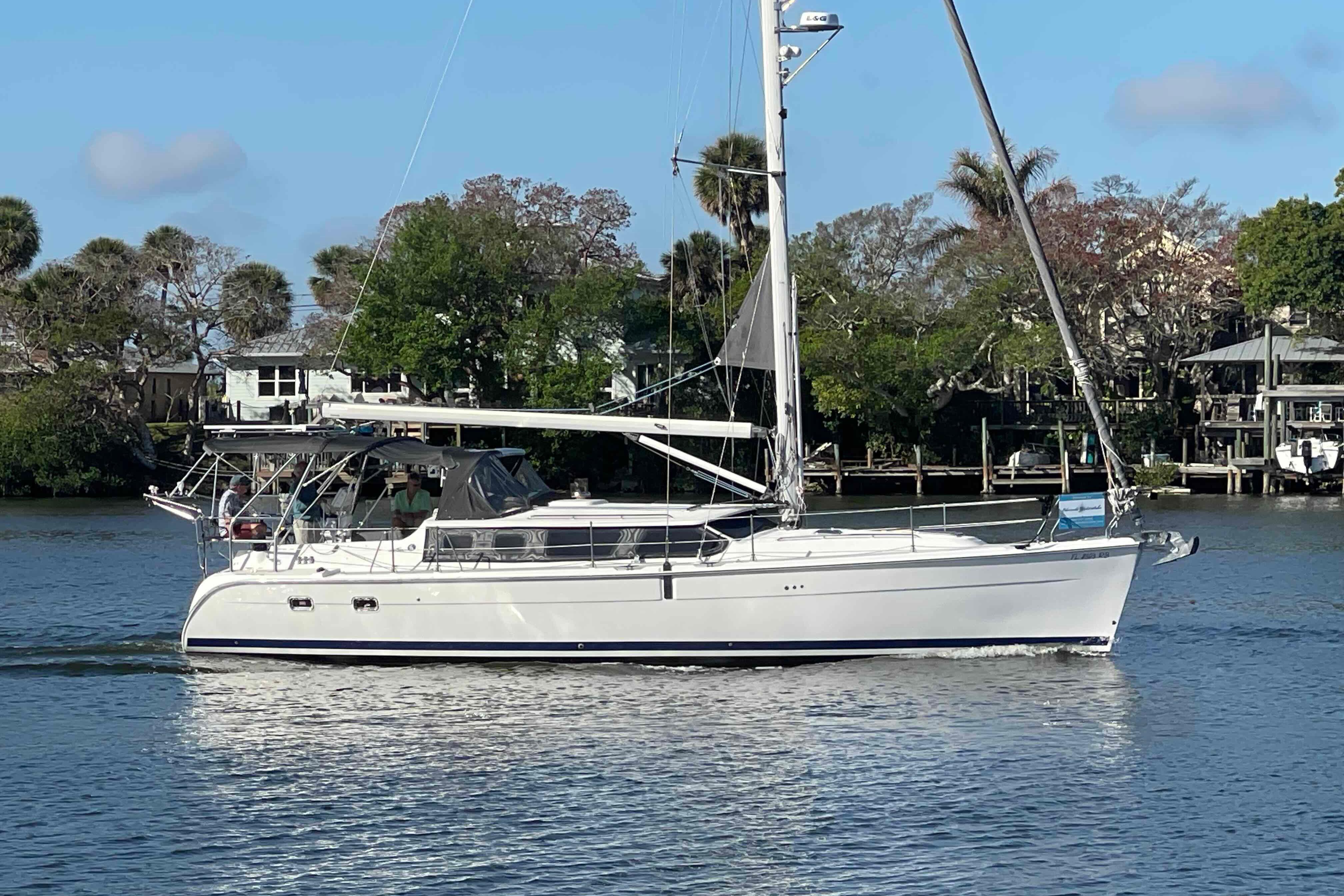 Hunter 426 Deck Salon 2003 sailboat cruising on a calm river with lush greenery.
