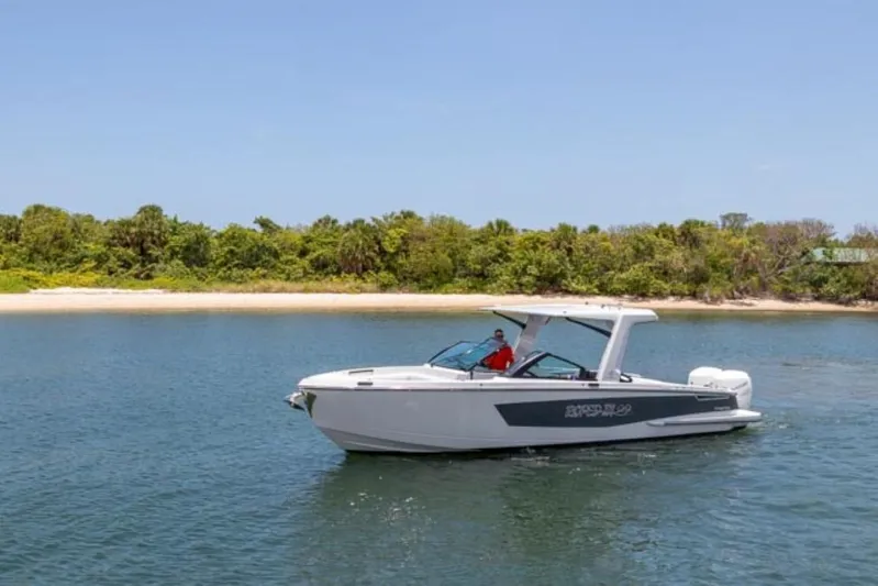  Yacht Photos Pics 2020 Aviara AV32 OB boat cruising near a lush, green shoreline.