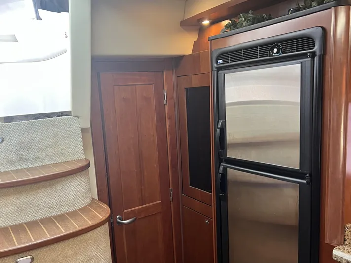  Yacht Photos Pics Interior of 2006 Sea Ray 48 Sundancer yacht with wooden cabinetry and stainless steel refrigerator.