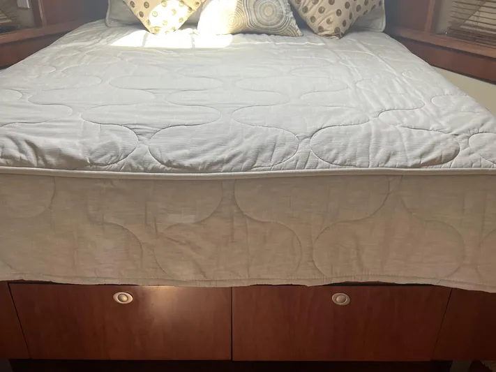  Yacht Photos Pics Bed in 2006 Sea Ray 48 Sundancer cabin with patterned pillows and wooden storage drawers.