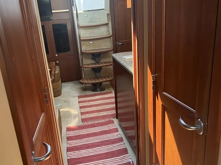  Yacht Photos Pics Interior of 2006 Sea Ray 48 Sundancer yacht with wooden cabinetry and striped rug.