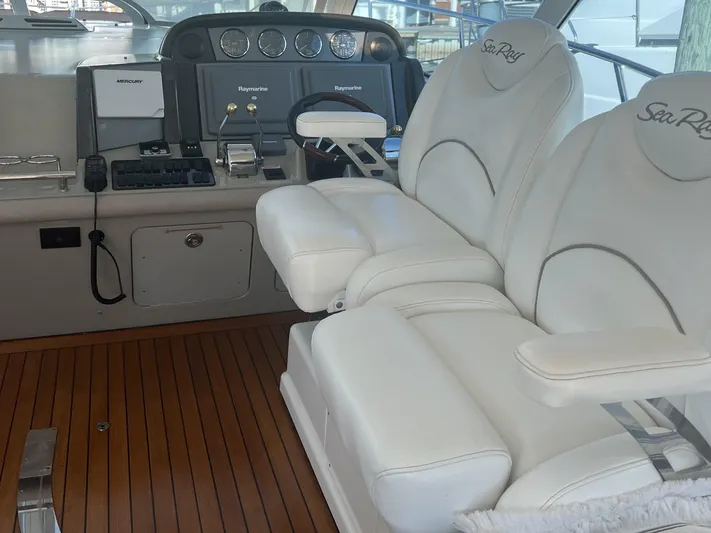  Yacht Photos Pics 2006 Sea Ray 48 Sundancer helm with white leather seats and wooden flooring.