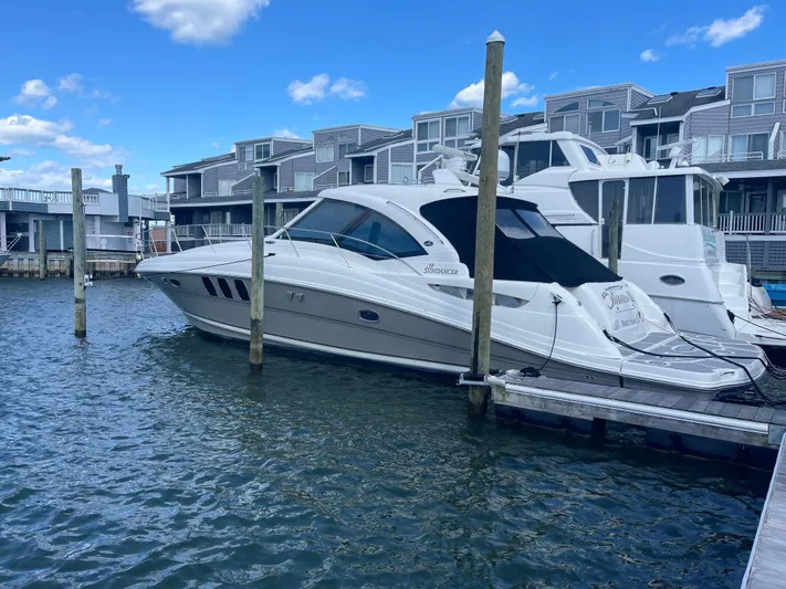  Yacht Photos Pics 2006 Sea Ray 48 Sundancer yacht docked at marina, surrounded by waterfront buildings.