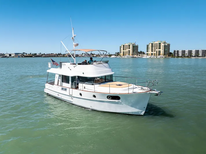 Lady Di Yacht Photos Pics 2012 Beneteau Swift Trawler 44 cruising on calm waters near modern buildings.