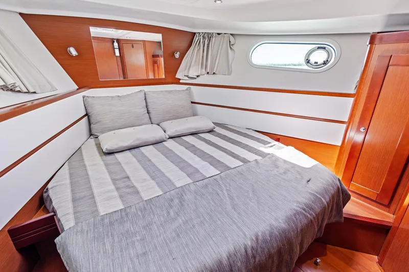Lady Di Yacht Photos Pics 2012 Beneteau Swift Trawler 44 cabin with cozy bed and wooden interior.