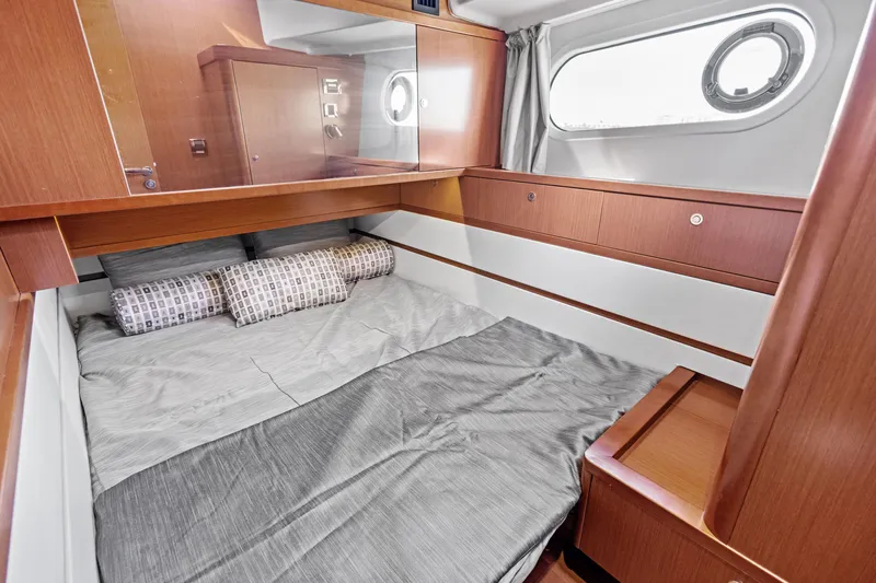 Lady Di Yacht Photos Pics Cozy cabin interior of 2012 Beneteau Swift Trawler 44 with wood finish and bedding.