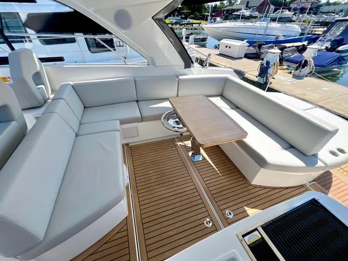 Vamanos Yacht Photos Pics Luxurious seating area on 2023 Beneteau Gran Turismo 41 yacht, featuring sleek design and wooden flooring.