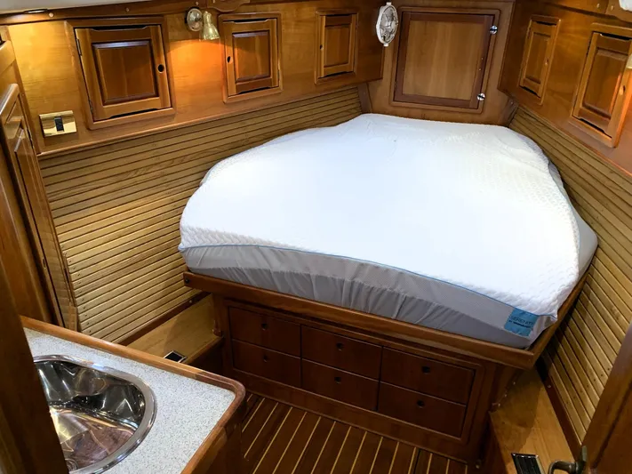 Wild Horses Yacht Photos Pics Luxurious wooden cabin interior of 2002 Saga 43 yacht with cozy bed and sink.