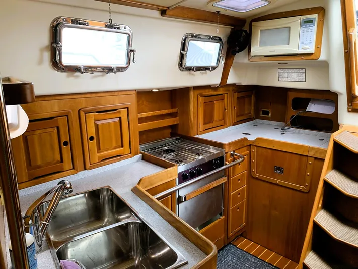 Wild Horses Yacht Photos Pics Wooden yacht kitchen interior with dual sink, stove, and microwave in a 2002 Saga 43 model.