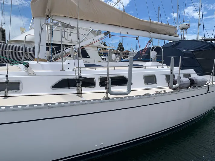 Wild Horses Yacht Photos Pics 2002 Saga 43 sailboat docked at marina, featuring sleek white hull and beige sail cover.