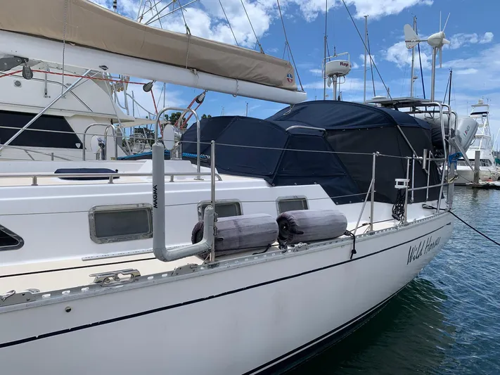 Wild Horses Yacht Photos Pics 2002 Saga 43 sailboat docked at marina, featuring covered deck and clear blue sky.