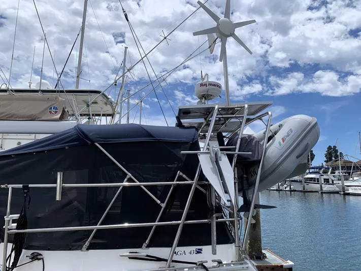 Wild Horses Yacht Photos Pics Saga 43 sailboat from 2002 docked at marina with wind turbine and dinghy.